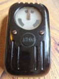 Vintage POST line tester with a round indicator window and ribbed black Bakelite housing, front view.
