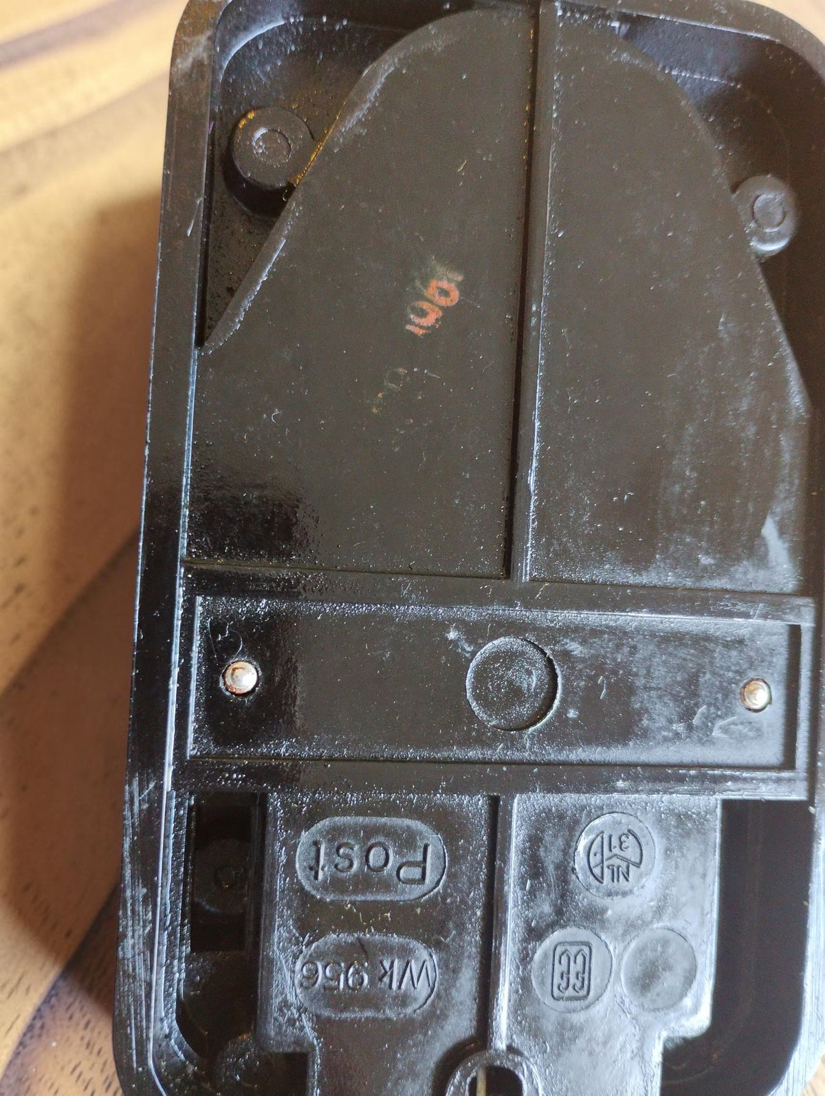 Rear of the vintage POST line tester showing molded markings, an orange-red ink stamp and signs of wear.
