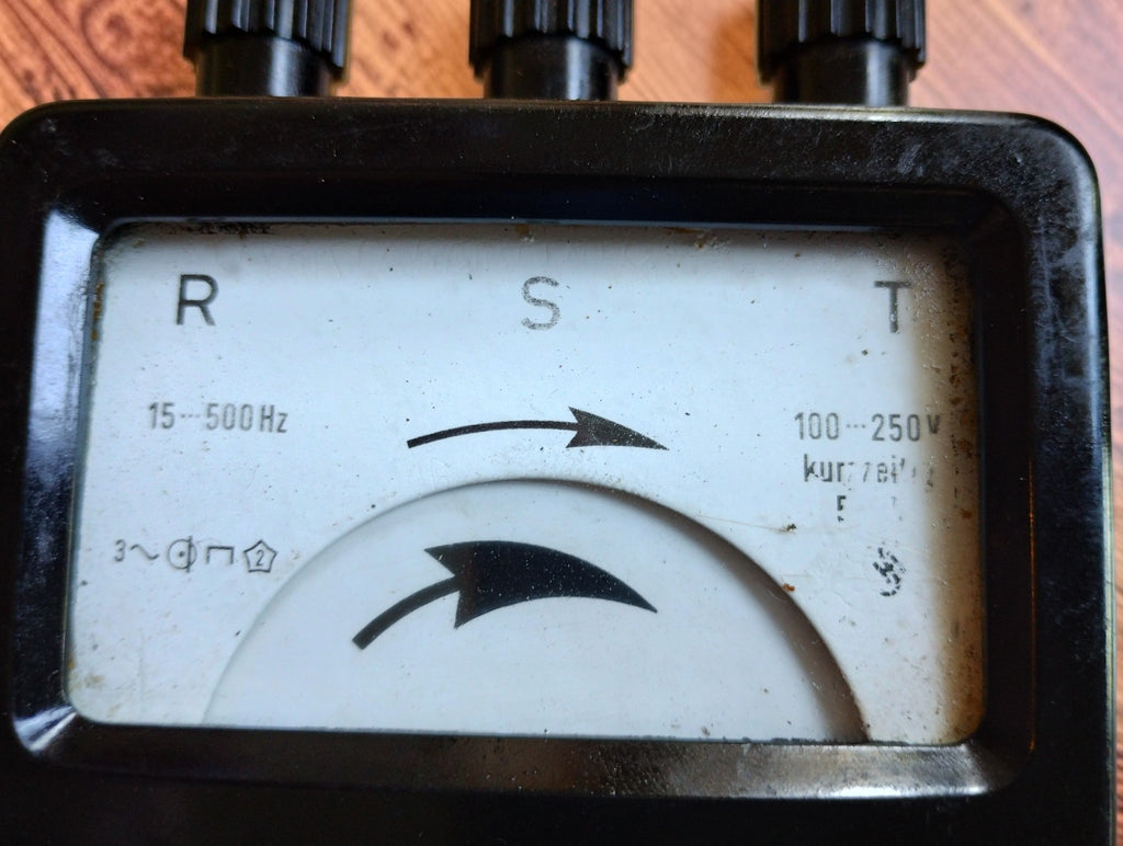 Close-up of Siemens phase sequence indicator dial showing R-S-T markings, direction arrows, 100–250 V and 15–500 Hz
