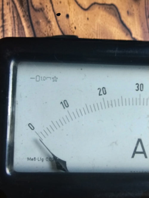 Close-up of the left side of the AEG ammeter dial, showing the pointer and the start of the 0–60 scale
