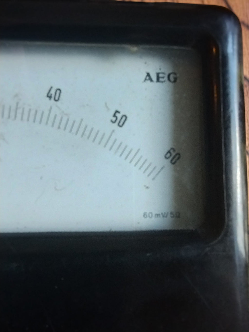 Close-up of the AEG logo and the 40–60 markings on the right side of the vintage ammeter dial
