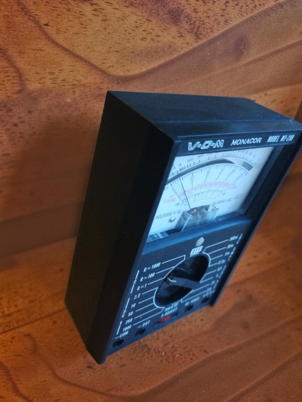 Angled side view of the Monacor MT-280 analog multimeter showing its compact black case
