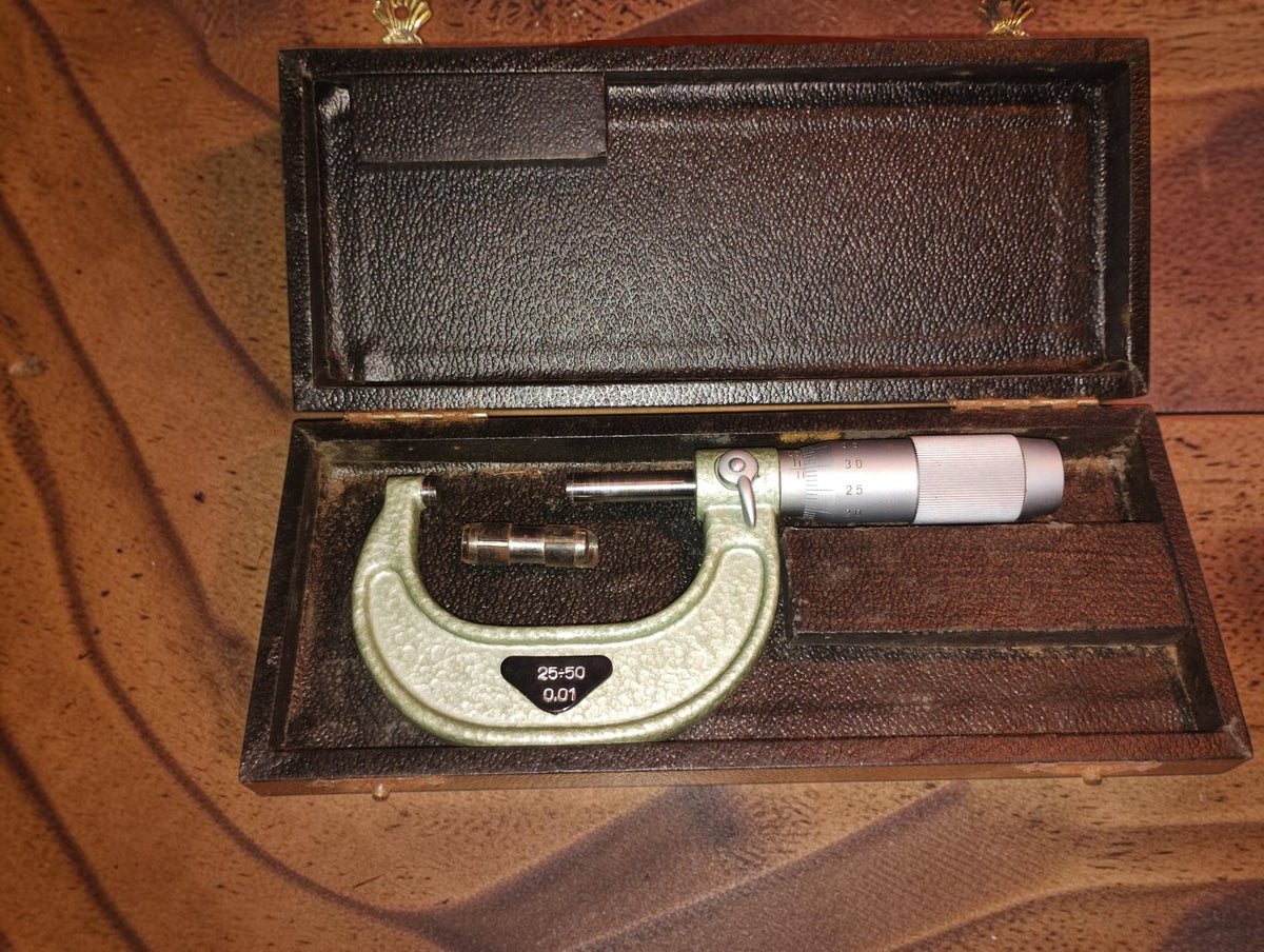 VIS 25–50 mm outside micrometer with setting standard in its open wooden storage box.
