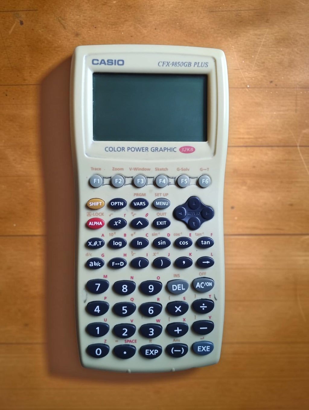 Front of the Casio CFX-9850GB PLUS White Edition graphing calculator, showing the screen and function keys.
