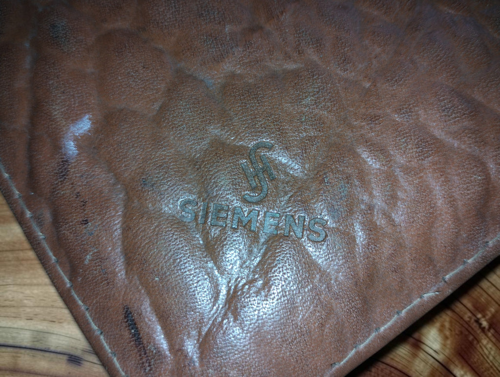Embossed Siemens name and emblem on the worn brown leather tool case
