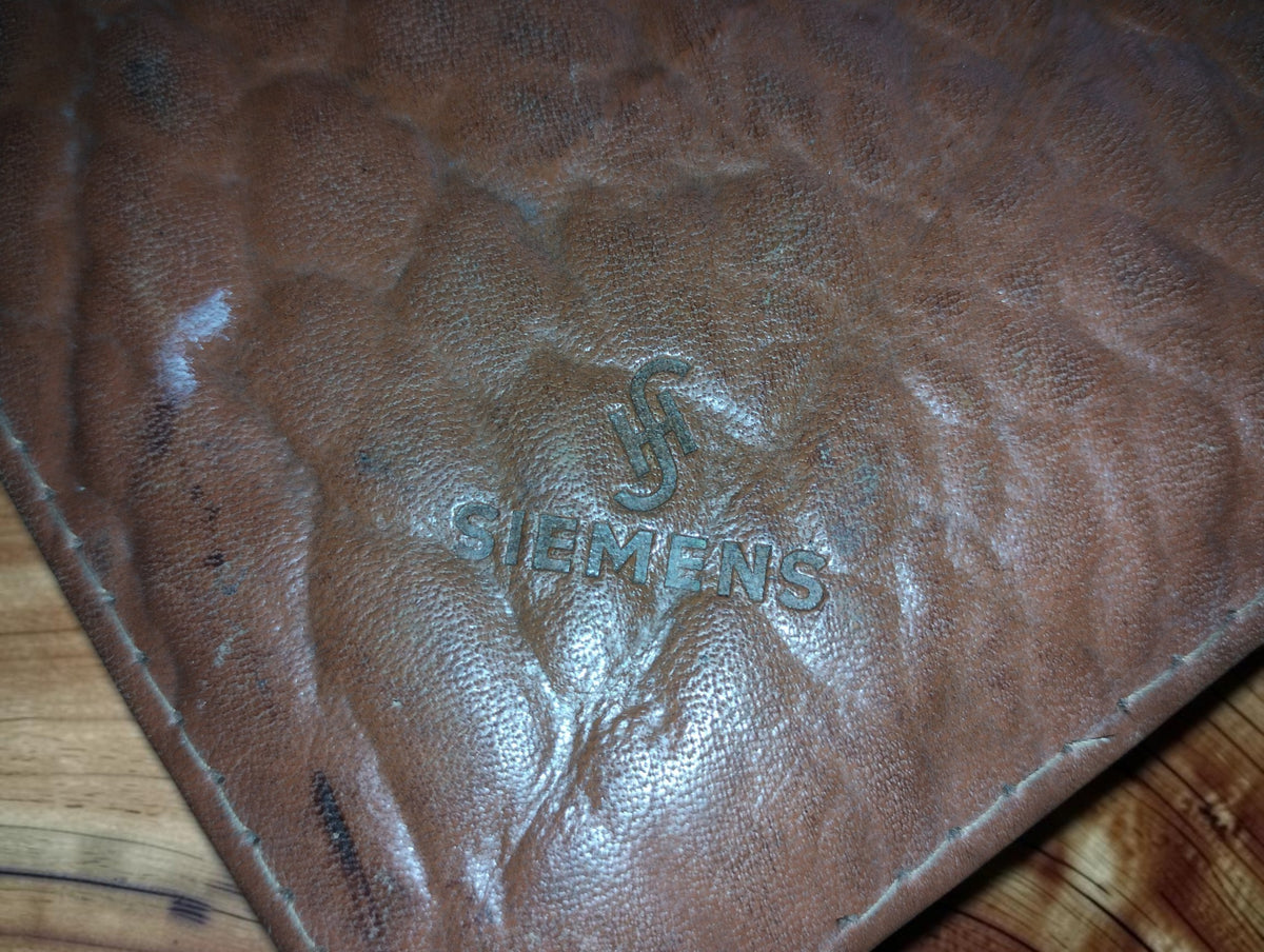 Embossed Siemens name and emblem on the worn brown leather tool case
