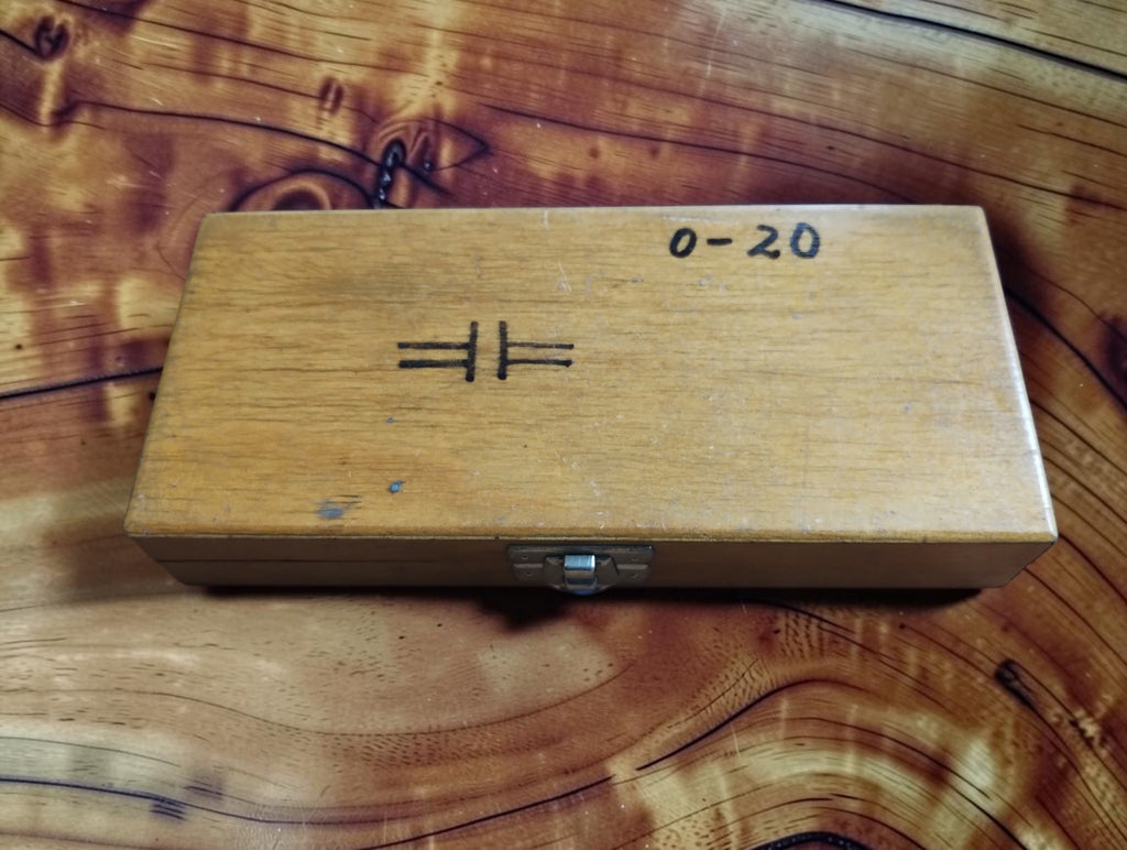 Closed wooden storage case for the Kunkel disc micrometer, with a handwritten 0–20 marking, measuring-face symbol and metal clasp.
