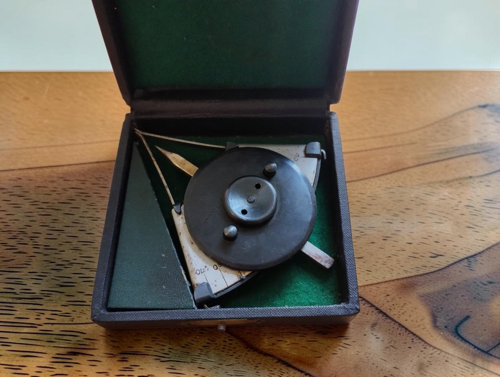 BBC Mannheim mechanical calculating instrument in its open black storage case with green lining.
