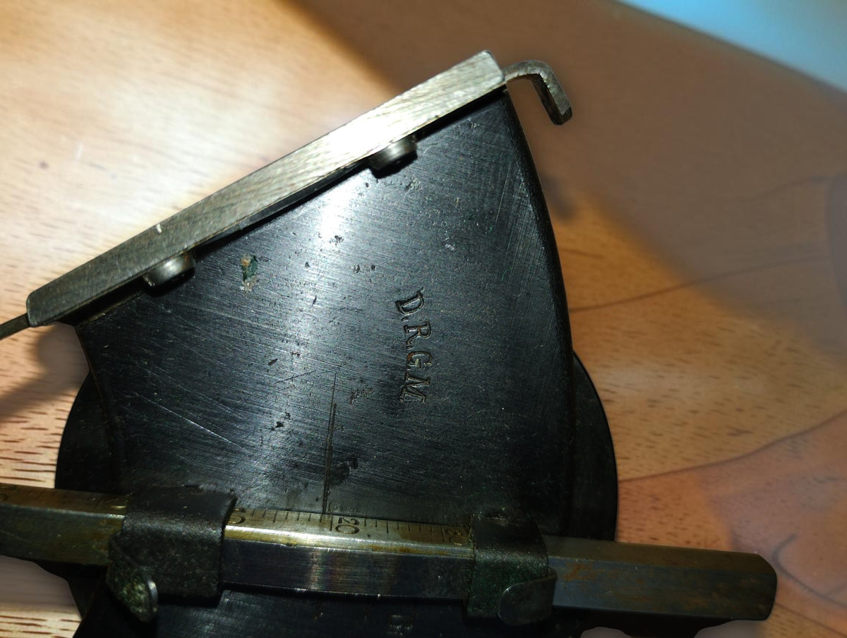 Close-up of the D.R.G.M. marking and sliding scale on the BBC Mannheim mechanical calculating instrument.
