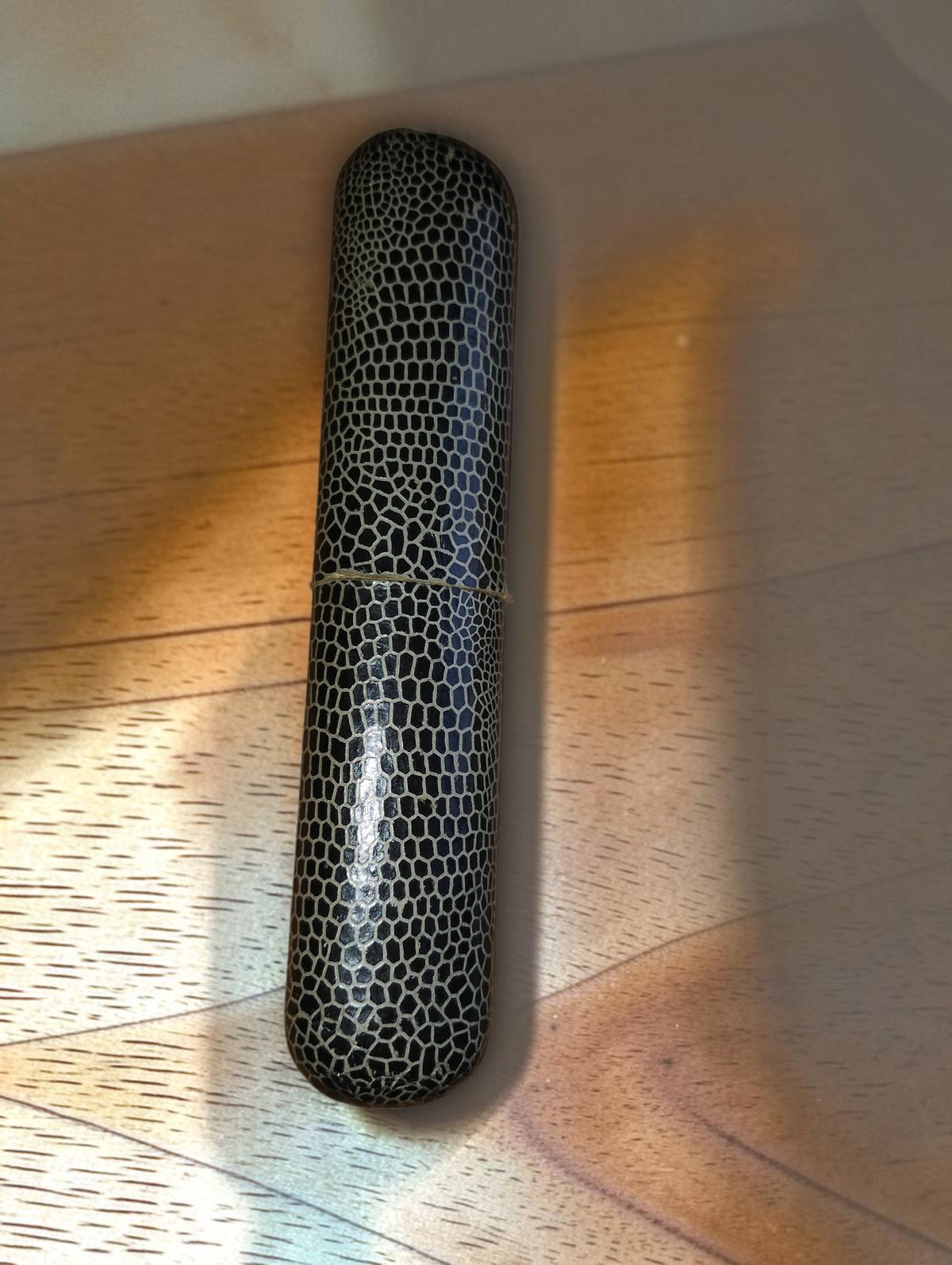 Closed vintage drafting instrument case with a black and silver reptile-pattern finish
