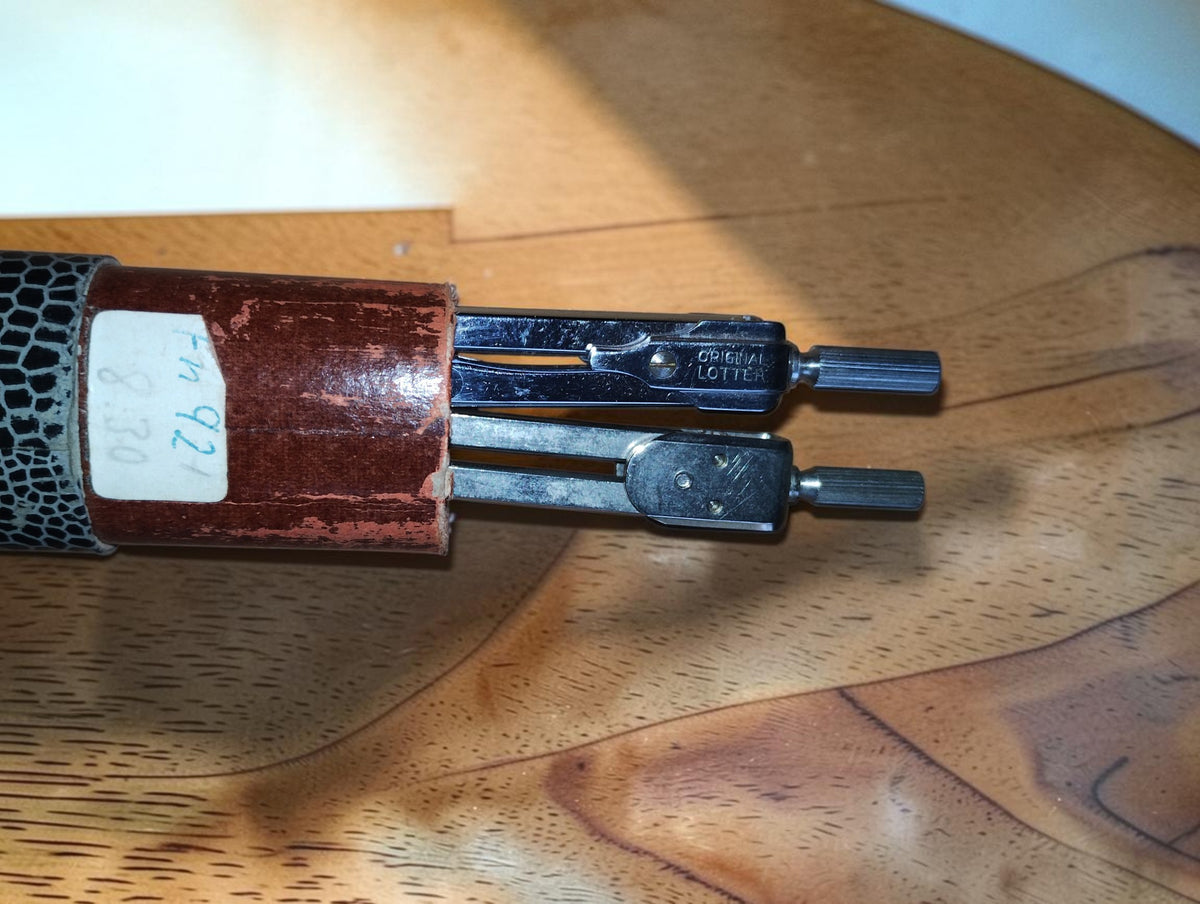 Two vintage drafting instruments partly exposed in their cardboard case, one marked ORIGINAL LOTTER
