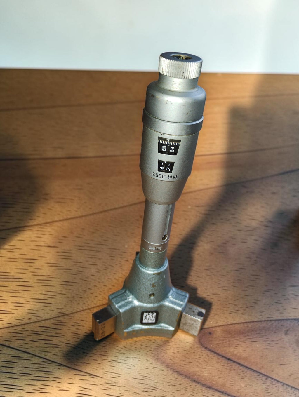TESA Swiss Made three-point internal micrometer standing upright, showing the readout windows and measuring head.
