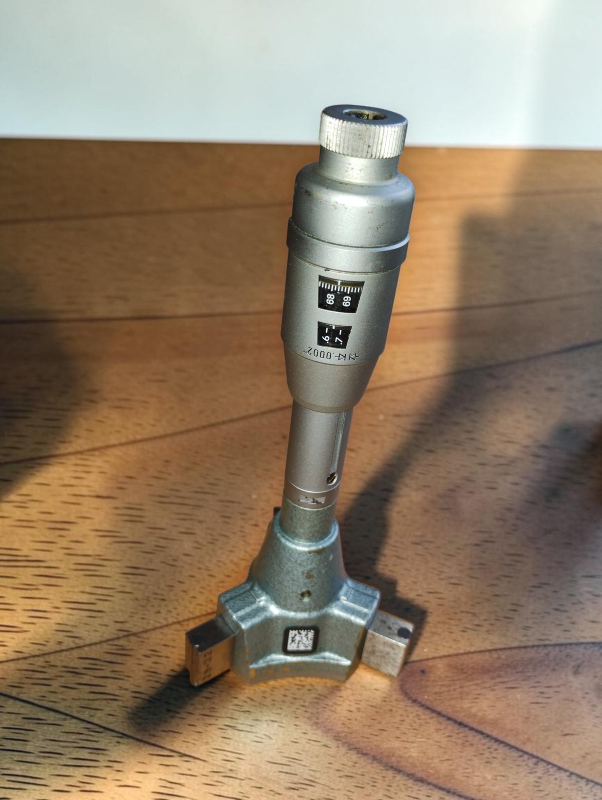 TESA Swiss Made three-point internal micrometer standing upright, showing the readout windows and measuring head.
