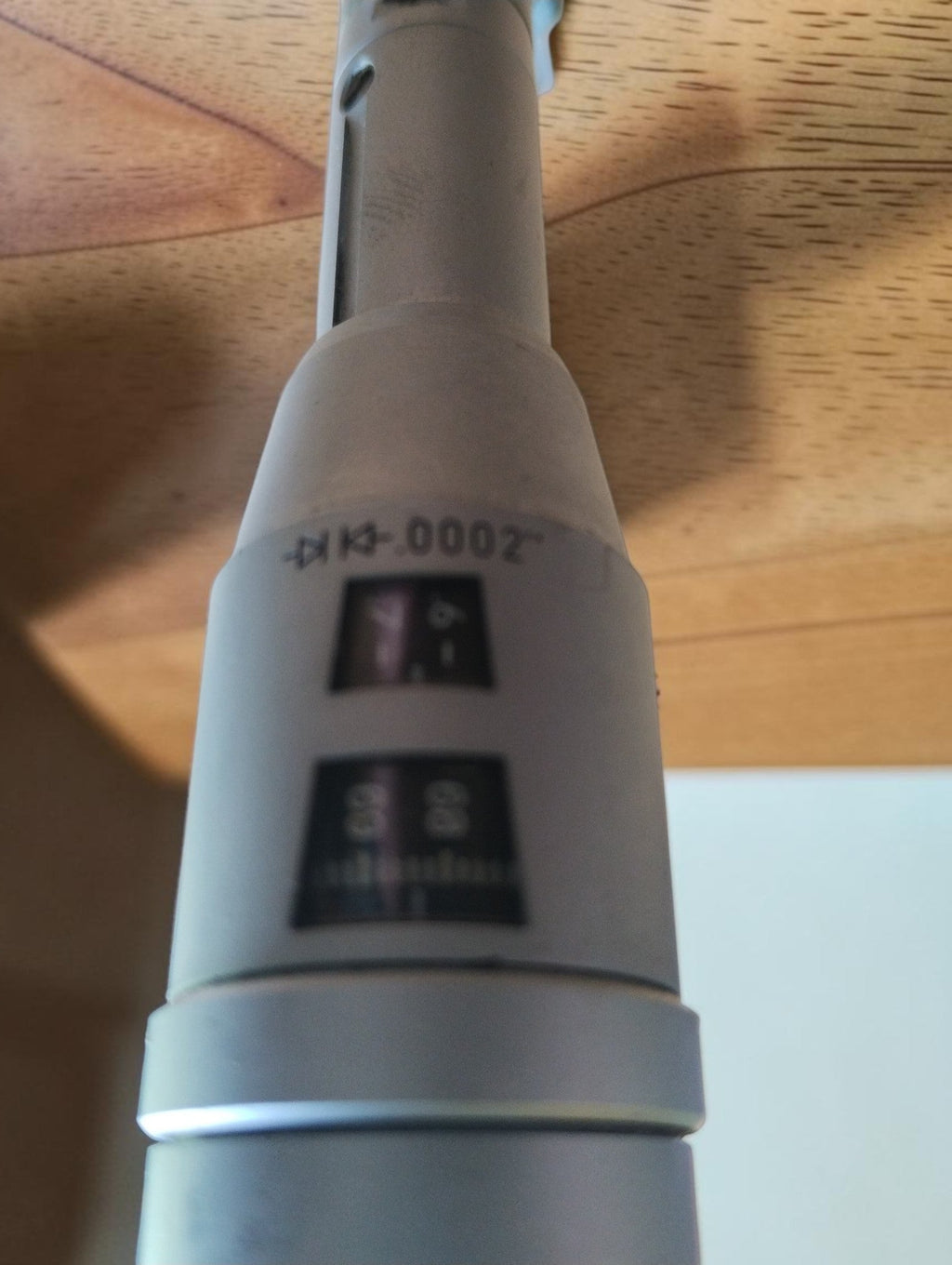 Close-up of the readout windows and metal body of the TESA Swiss Made internal micrometer.
