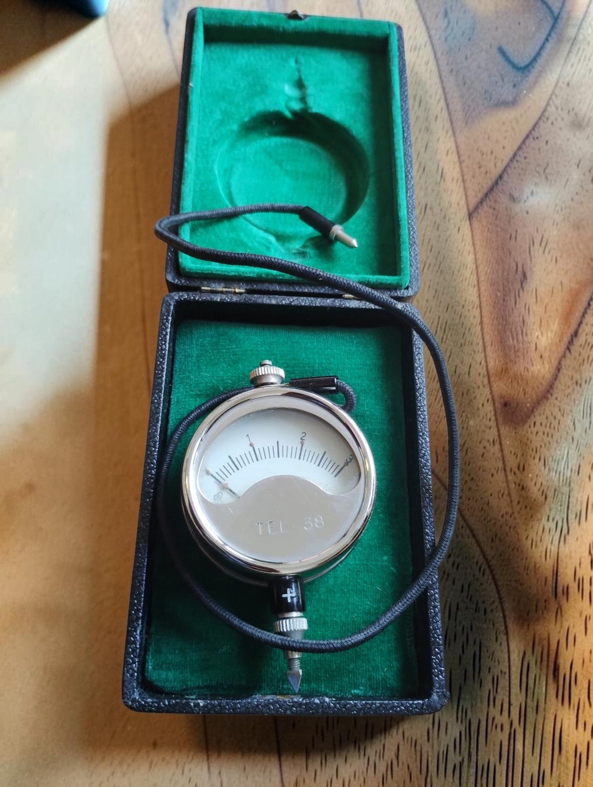 Metrawatt TEL-38 pocket voltmeter with cloth-covered test lead in its open green-lined case

