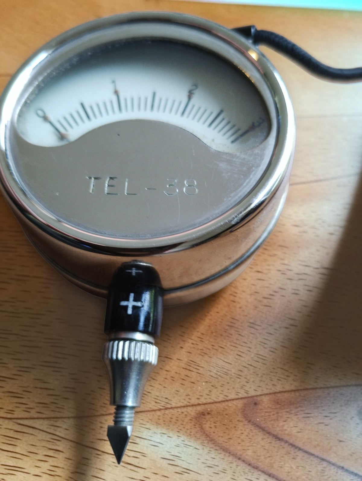 Front view of Metrawatt TEL-38 pocket voltmeter with chrome housing and positive probe
