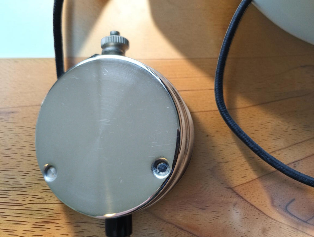 Rear view of Metrawatt TEL-38 pocket voltmeter showing the metal back plate and cloth-covered lead
