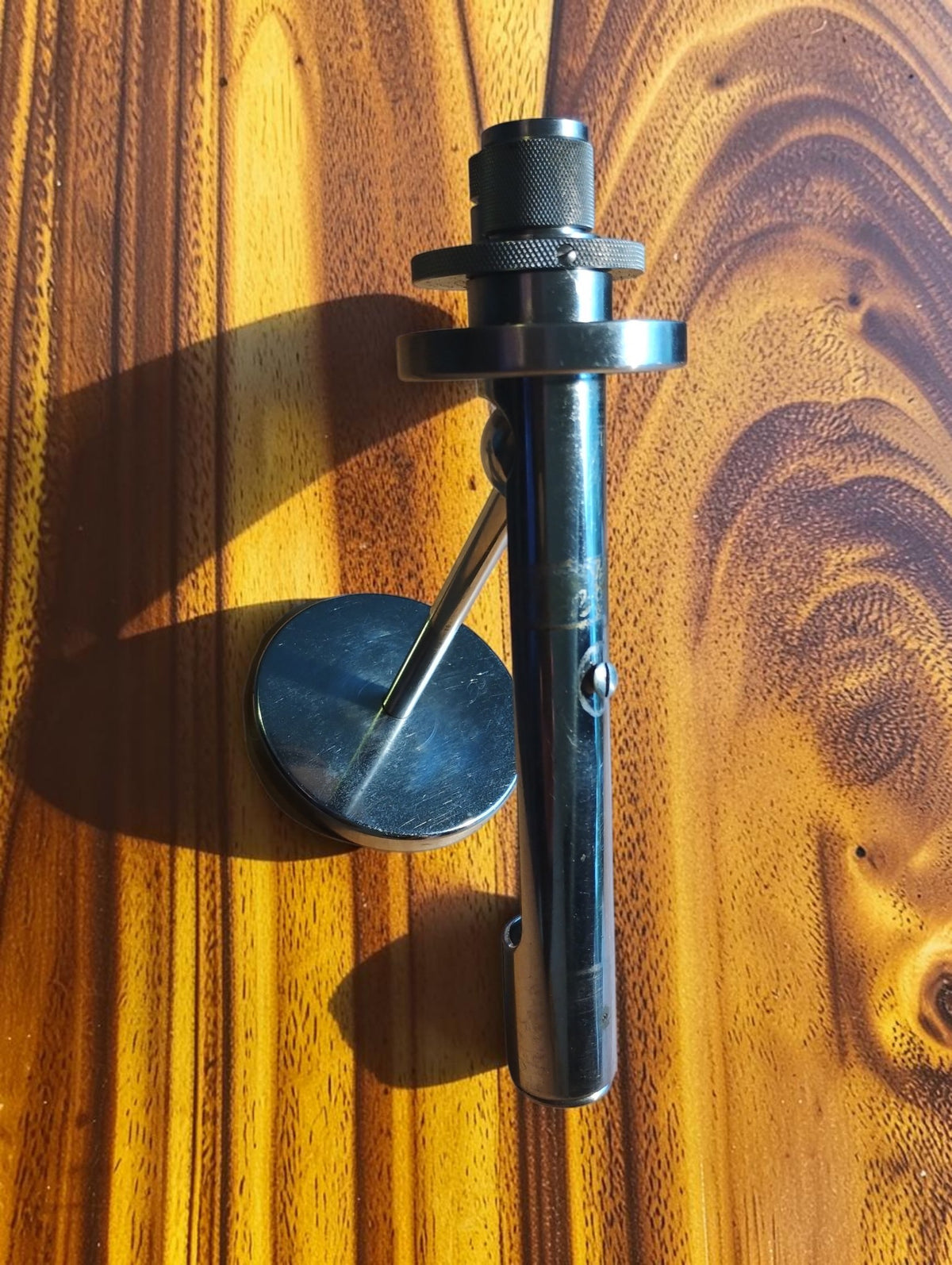 Carl Zeiss Jena vertical illuminator with adjustable rings and attached round mirror, shown on a wooden surface
