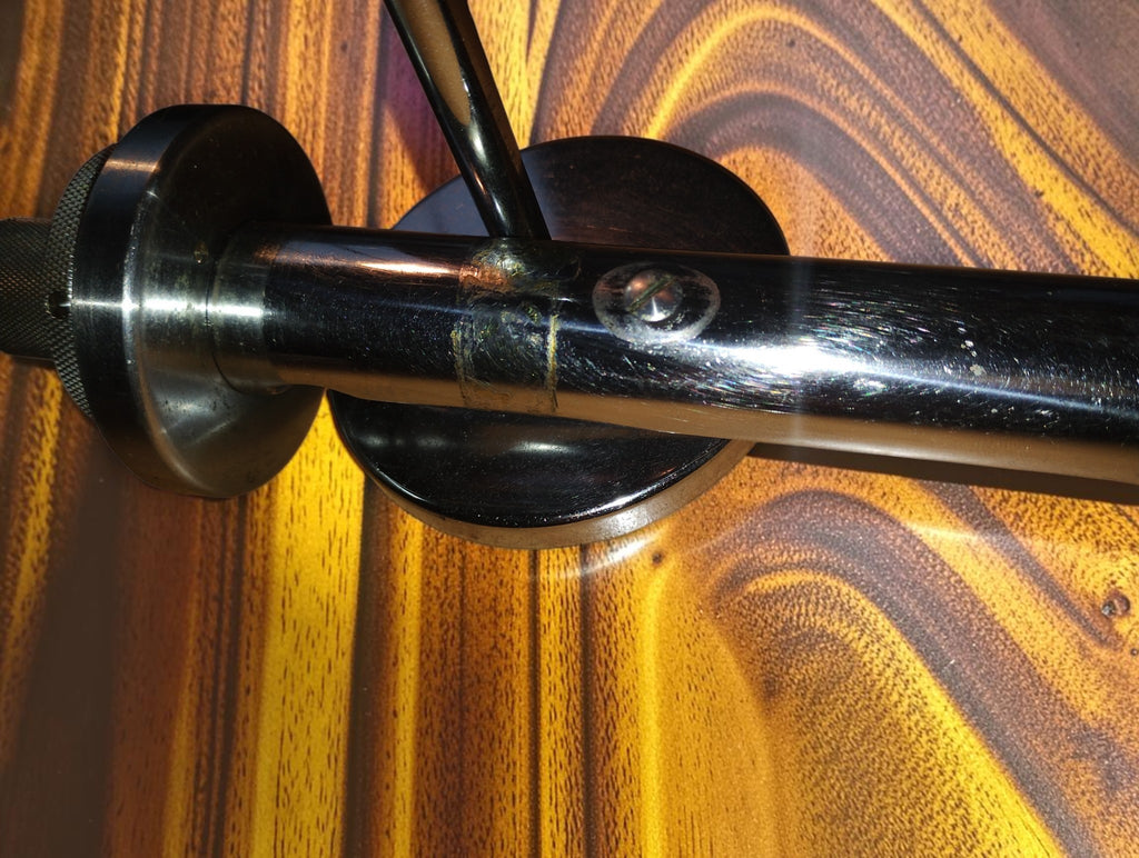 Side detail of the Carl Zeiss Jena vertical illuminator showing the mirror support, screw and scratches on the body
