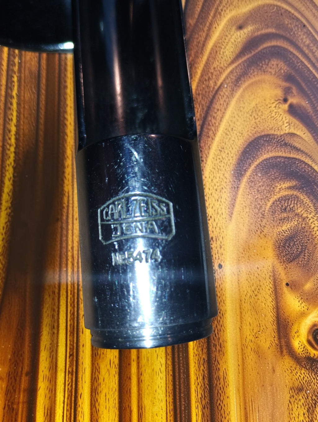 Close-up of the engraved Carl Zeiss Jena logo on the vertical illuminator, showing wear to the metal finish
