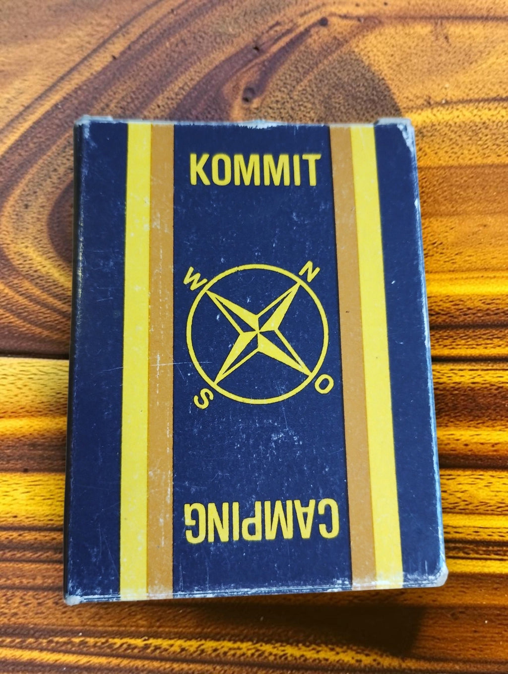 Original Kommit Camping compass box with a compass rose design and visible edge wear
