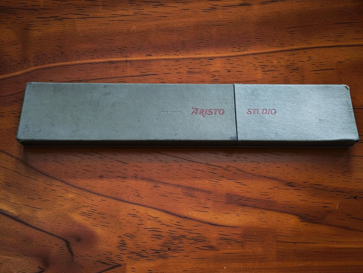 Closed gray two-piece case with ARISTO Studio lettering on a wooden surface.
