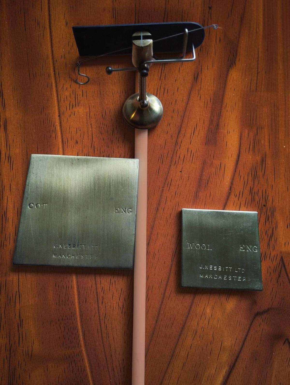 John Nesbitt yarn balance displayed with its separate brass COT and WOOL plates on a wooden surface.
