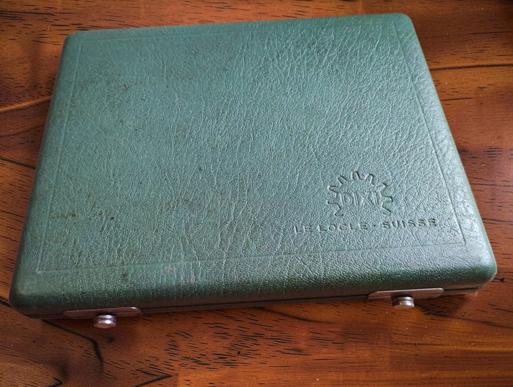 Closed green DIXI Le Locle precision watchmaking tool case with textured covering and two silver-colored clasps
