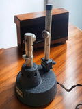 PHYWE Göttingen vintage optical laboratory ensemble with two metal uprights, a round black textured base, and a fabric-covered cable.



