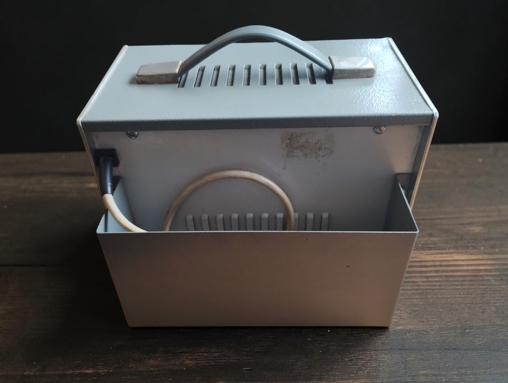 Rear view of the Müter BMR 7 CRT tester showing the metal cable storage compartment and carrying handle
