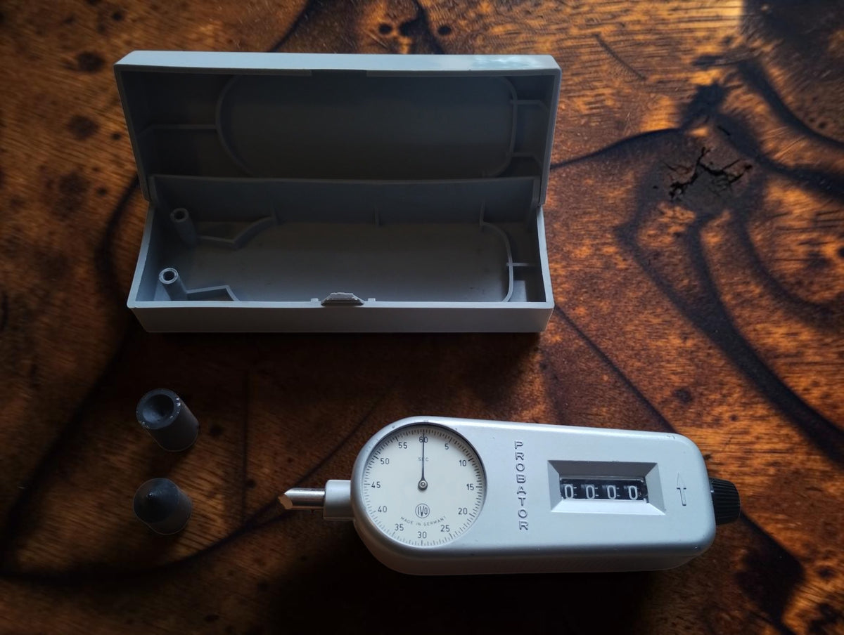 IVO Probator hand tachometer beside its open storage case and two rubber contact tips
