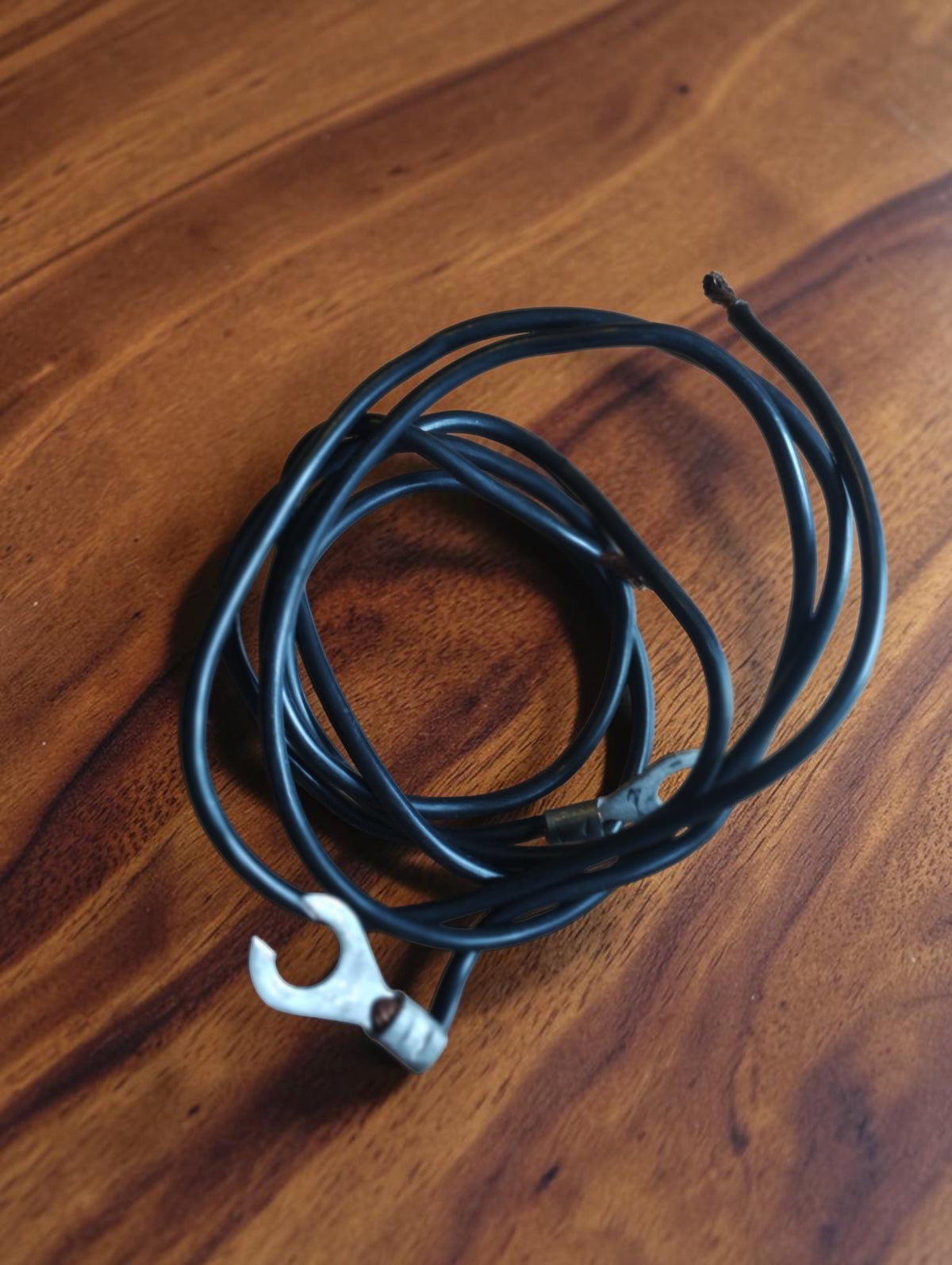 Black connecting cable with a fork terminal and exposed connector end, supplied with the vintage DC volt and amp meter.
