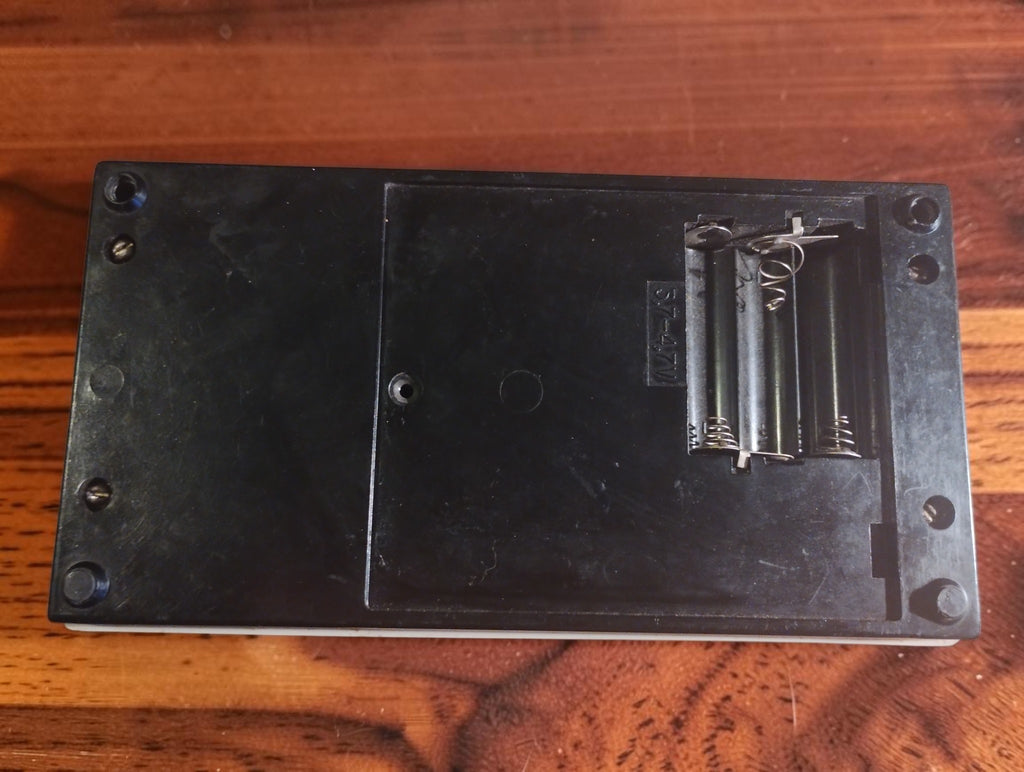 Rear view of the Ц4353 В4.1 analog multimeter, showing the black base and open, empty battery compartment.
