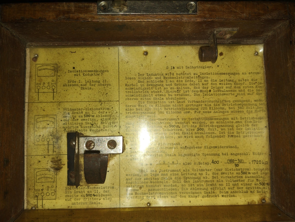 Original German instruction sheet inside the wooden lid, showing connection diagrams and insulation measurement procedures.
