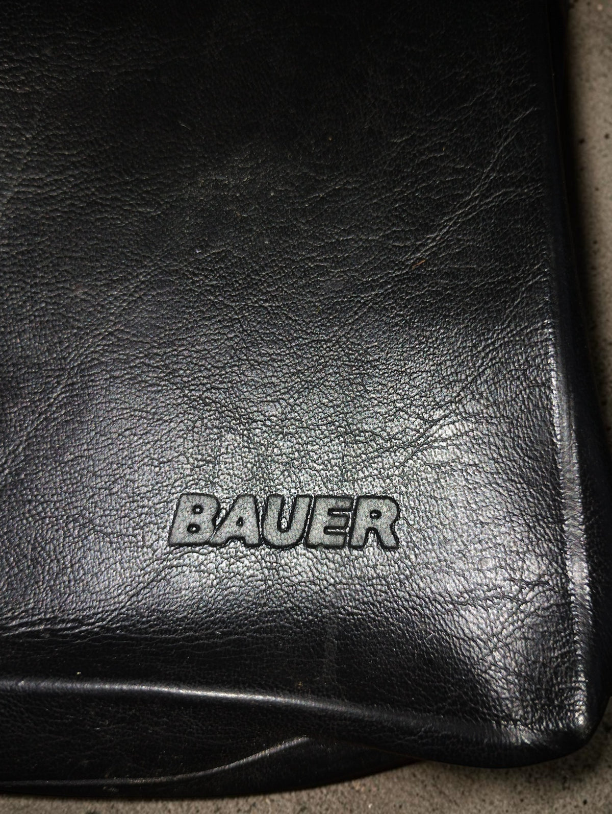 Close-up of the embossed Bauer logo on the black vintage camera carrying bag
