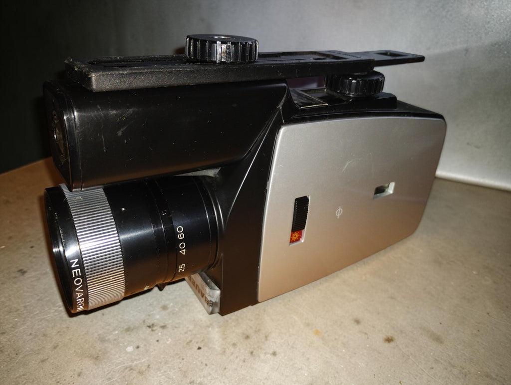 Side view of the Bauer C8 makro Super 8 movie camera showing the silver film compartment cover and Neovaron lens
