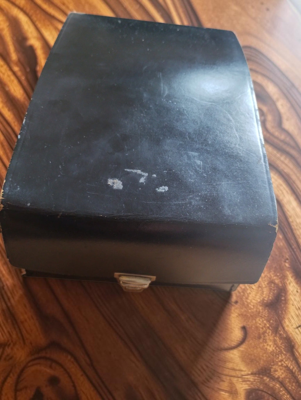 Black storage box with metal clasp and visible surface wear for the ELIMA Elavi 1 multimeter
