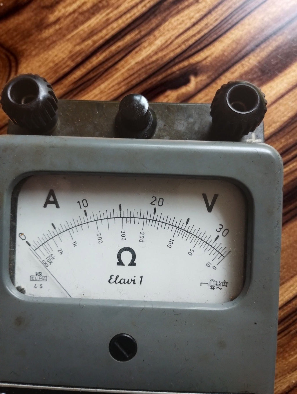 Close-up of the ELIMA Elavi 1 analog multimeter dial with voltage, current and resistance scales
