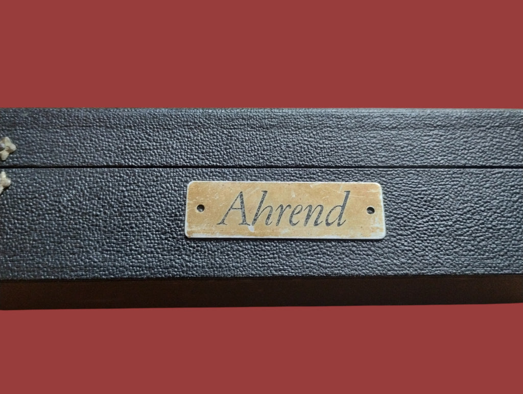 Close-up of the brass Ahrend dealer plate on the original black planimeter case
