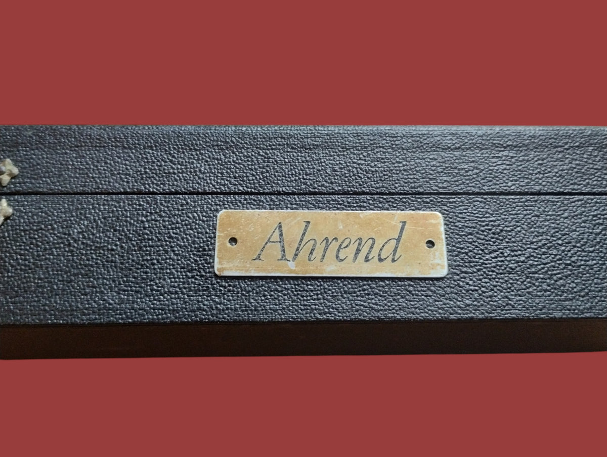 Close-up of the brass Ahrend dealer plate on the original black planimeter case
