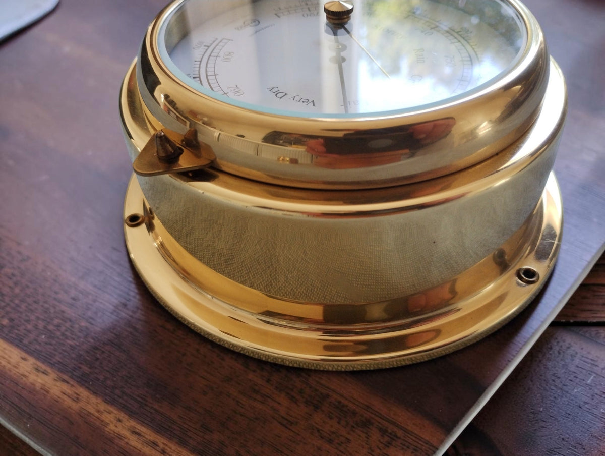 Side view of the BARIGO barometer showing its cylindrical gold-tone case, front closure and mounting holes.
