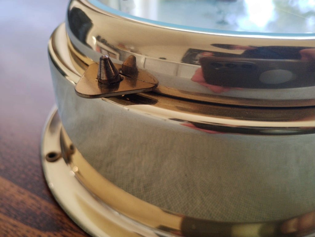 Close-up of the triangular closure on the BARIGO barometer's gold-tone case, showing localized discoloration.
