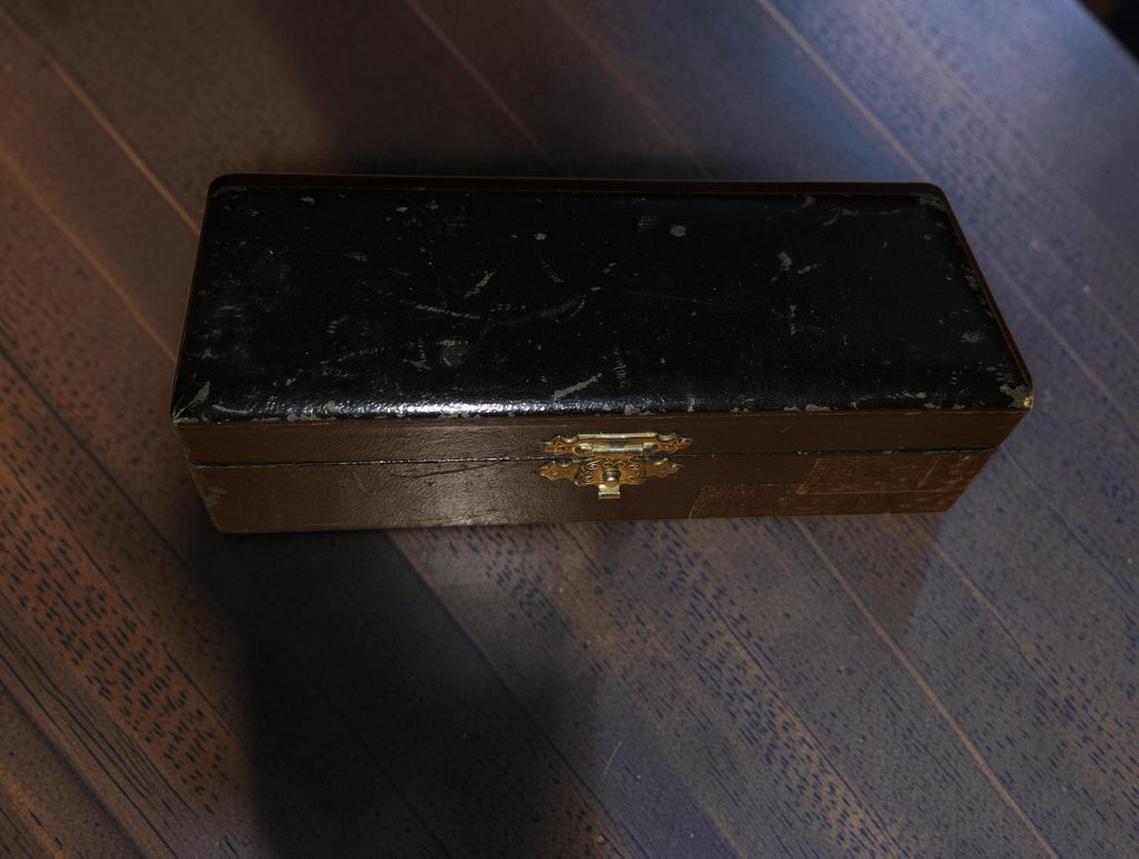 Closed wooden storage case for the IVO PROBATOR hand tachometer with black lid, metal clasp and visible wear
