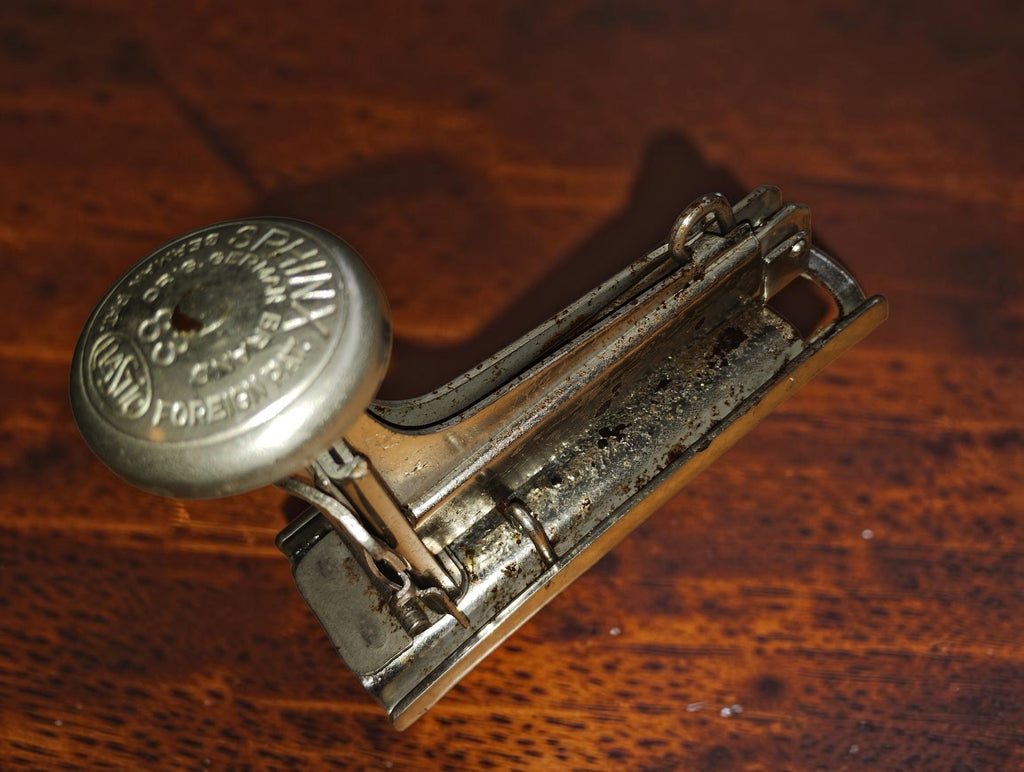 Zijaanzicht van de Elastic Sphinx No. 83 nietmachine met slijtage aan het metalen frame
