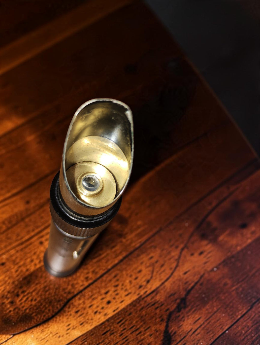 Detail van de schuine opening van de zakmicroscoop met zichtbaar metalen binnenwerk en lens

