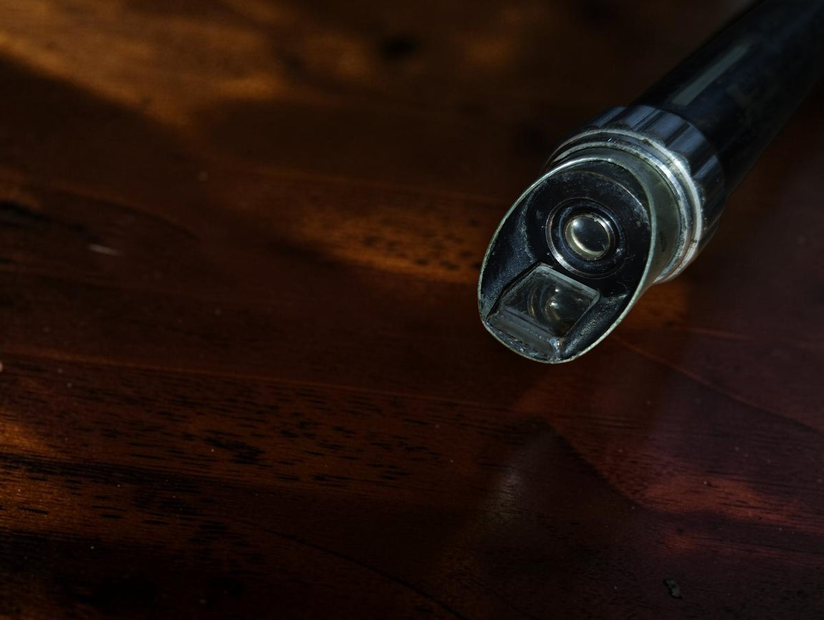 Detail van de schuine kop van de zakmicroscoop met lens en rechthoekig reflecterend onderdeel
