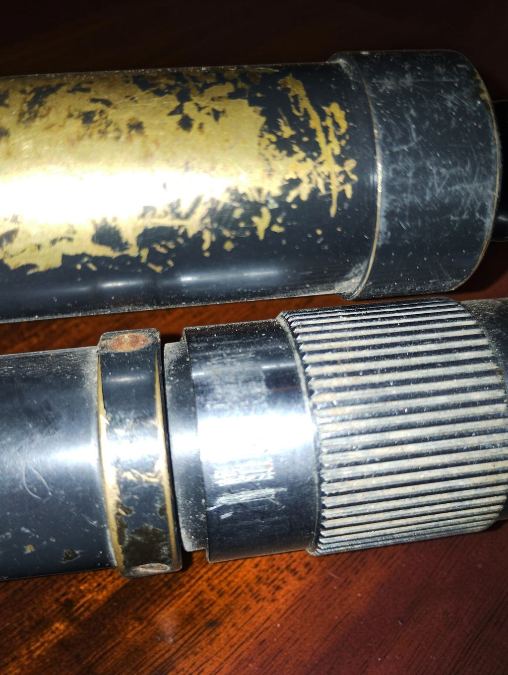 Detail of the ribbed adjustment ring and scratches and paint loss on the microscope and lamp cylinder.

