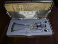 SK Schiötz tonometer in its open fitted case with additional weights and printed documentation.
