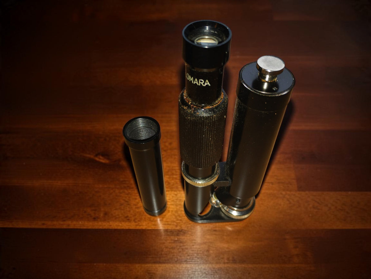 
Ultra-Lomara pocket microscope viewed from above, with its eyepiece visible and a separate tube on the left.
