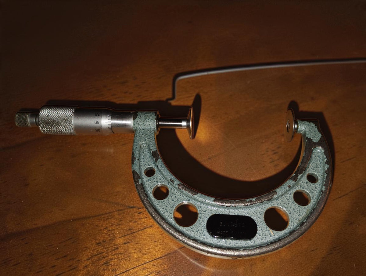 Andere zijde van de Mitutoyo schijfmicrometer met schaalverdeling, meetspindel en schotelbekken
